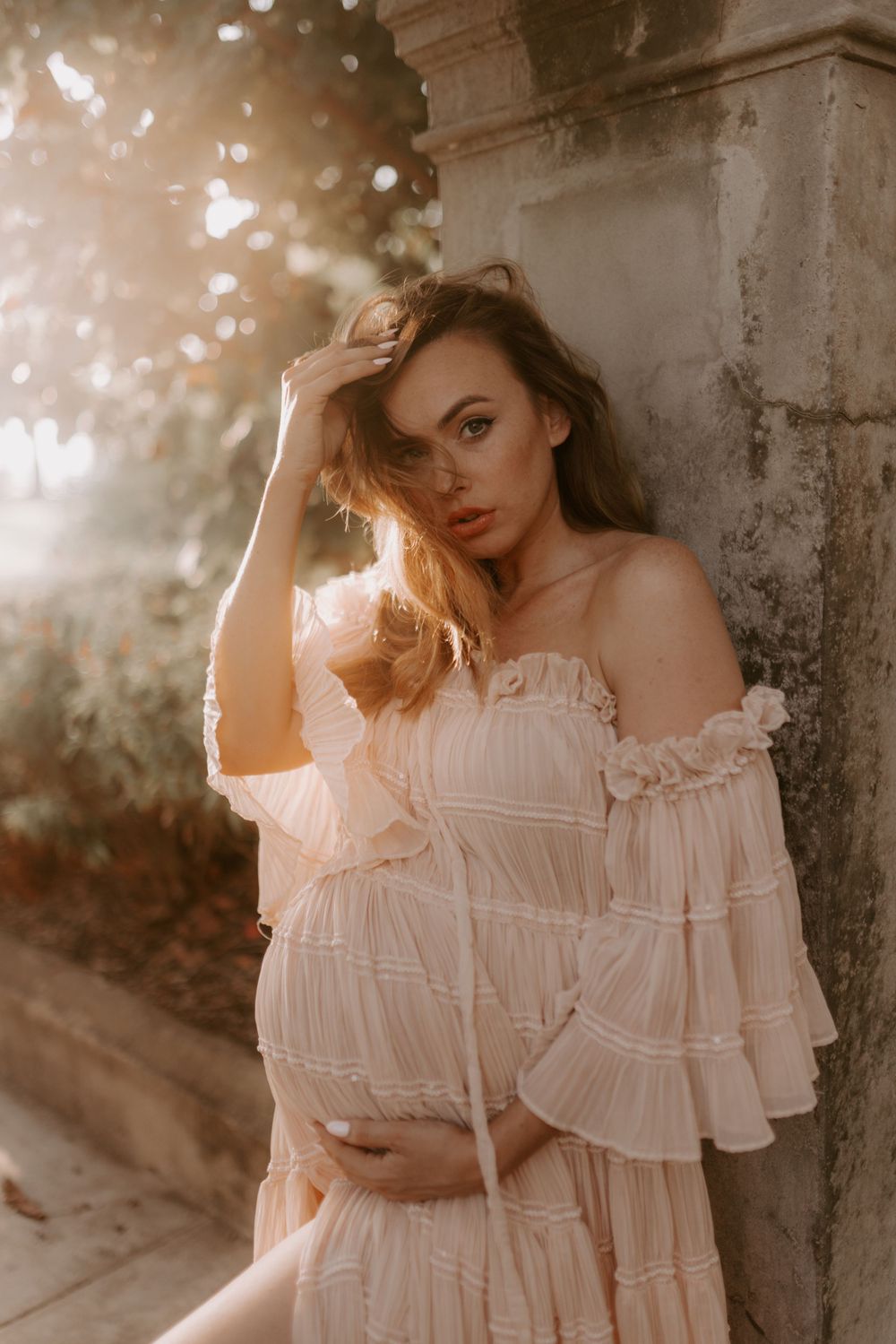 Romantic photoshoot featuring an off-shoulder white dress in ethereal lighting.
