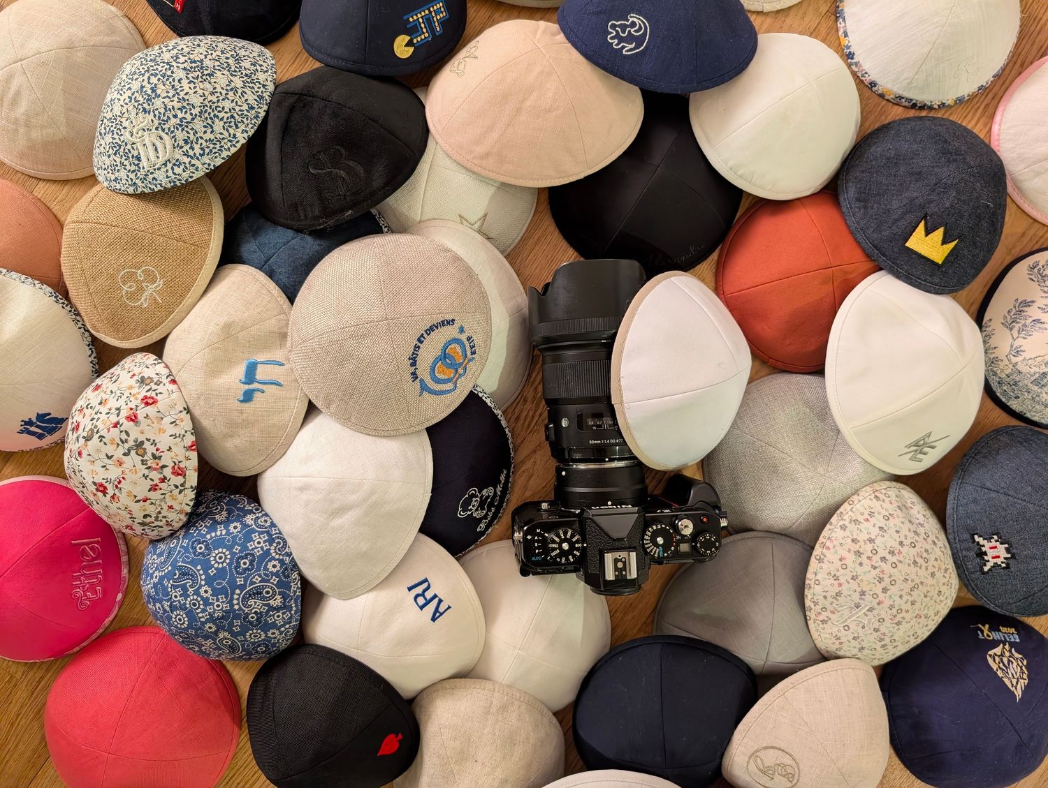 Collection de kippot colorées posées ensemble, détail élégant d’une préparation de cérémonie juive.