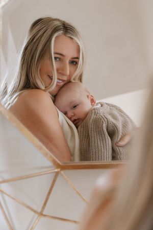 Mirror reflection showing tender moment in a bright, minimal interior.