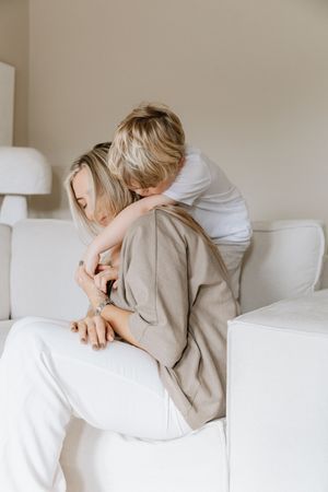 Tender moment shared on a white couch showing affectionate embrace.