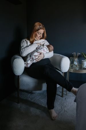 Family lounging together in a cozy dark room with soft lighting and cushions.