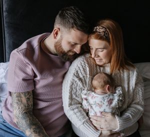 Intimate family moment captured in muted tones with soft winter knit sweaters.