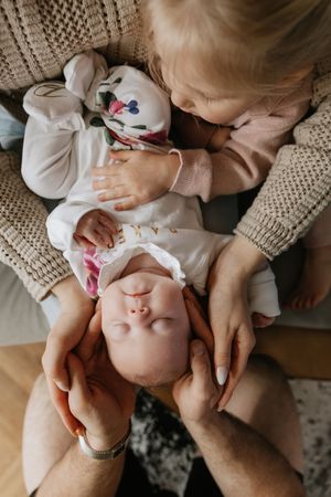 An overhead view of a tender family moment on a knit sweater background.