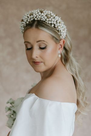 Delicate bridal portrait showing white floral crown and soft romantic makeup.