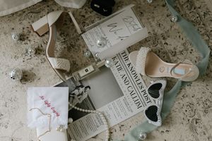Vintage style tea bags with handwritten labels and heart shapes lay scattered on a weathered concrete surface.