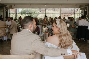 Wedding reception dance floor scene with guests celebrating in an airy venue with natural lighting.