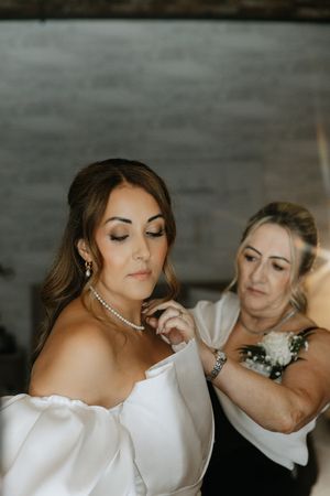 A series of close-up photos showing elegant bridal jewelry and details of a white wedding dress.
