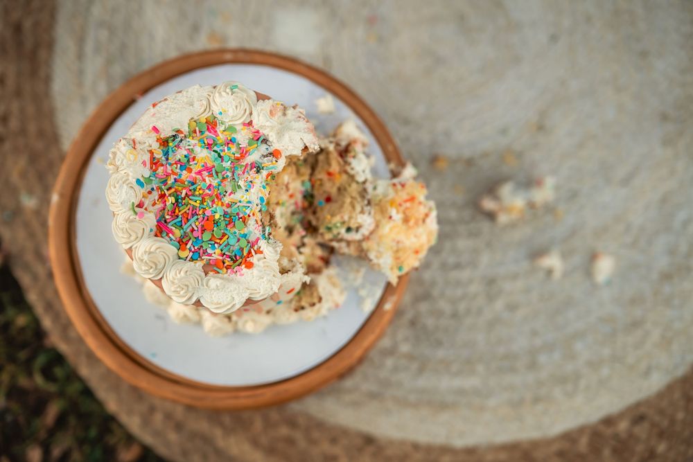 The top down view of a small cake that has been smashed by little hands for a first birthday cake smash session.