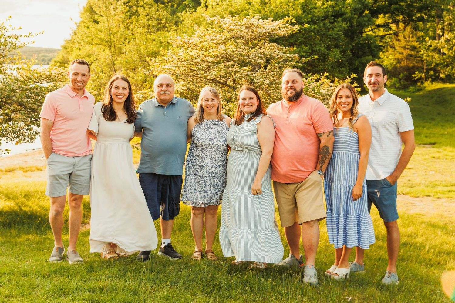 Family group photo outdoors with everyone dressed in summer casual attire.