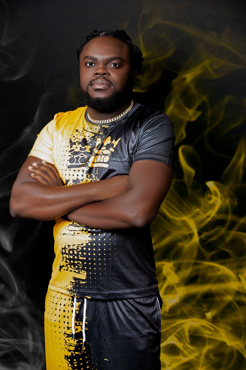 Professional portrait showcasing dramatic yellow and black outfit against dark background with smoky effects.