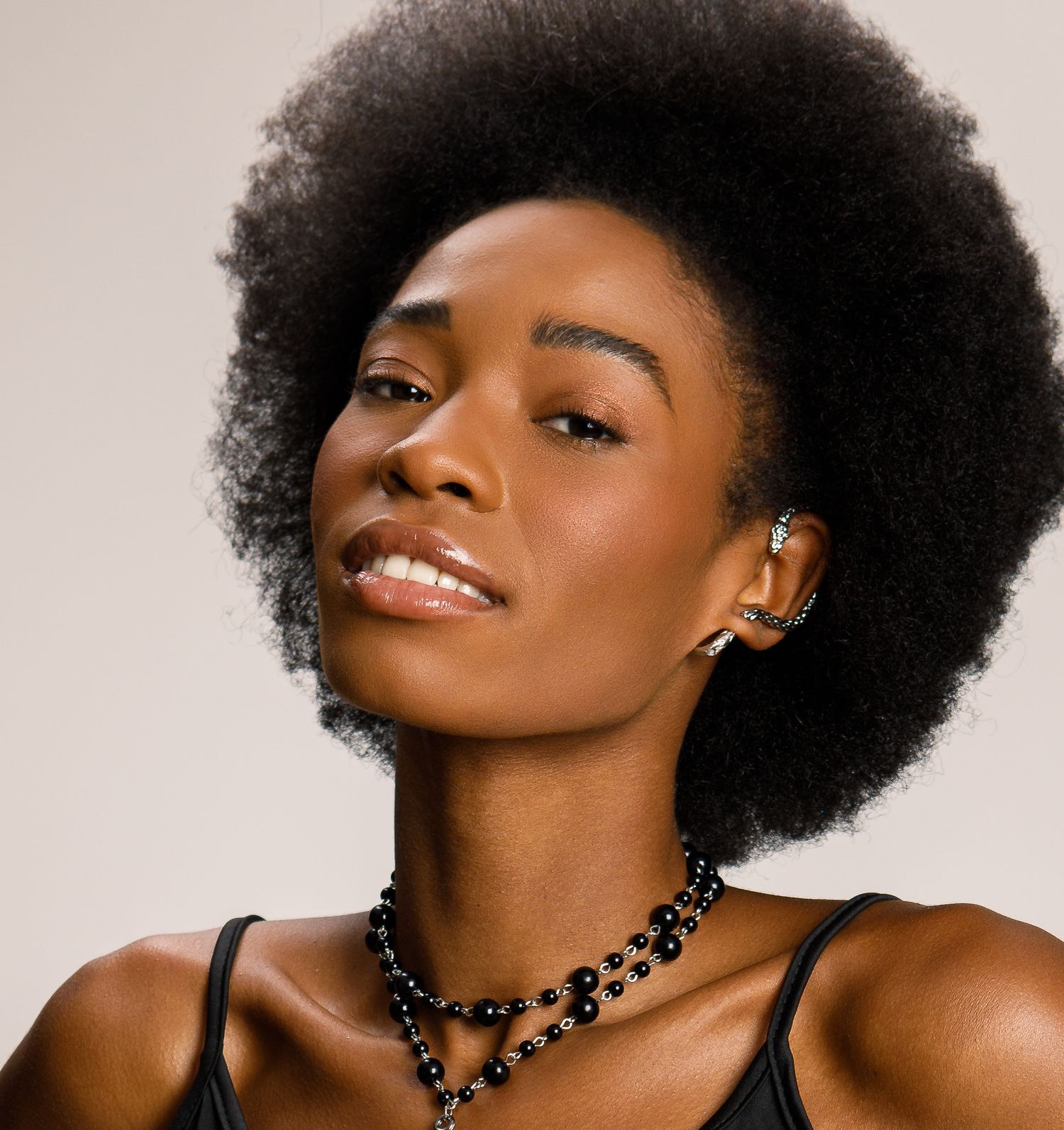 An exotic look with iridescent greens and blues on the eyes. A natural afro style.