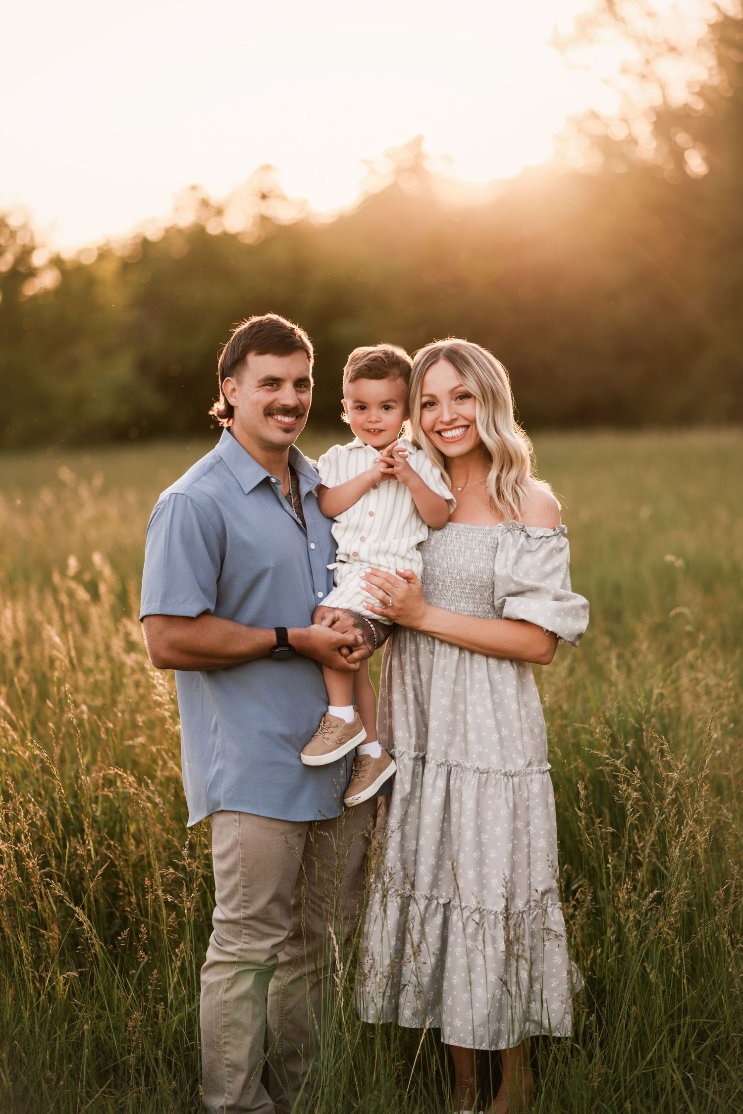 Happy family of four embracing warmly among colorful autumn foliage in an outdoor fall portrait.