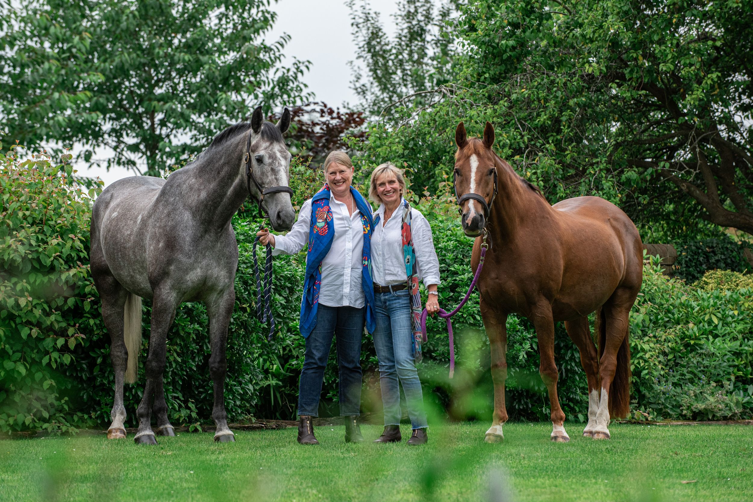 Life long best friends and horse owners with their horses during autumnal equine portrait photoshoot