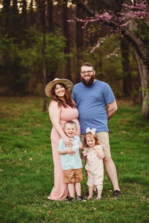 Spring family portrait with blooming cherry blossoms in the background.