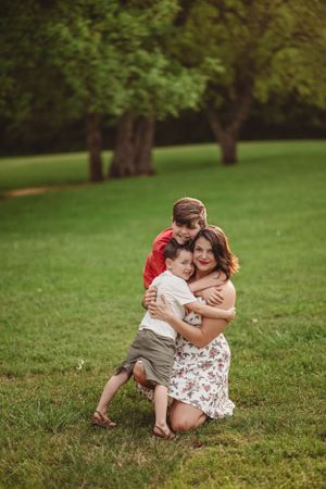 A playful outdoor family photoshoot on green grass during a sunny day.