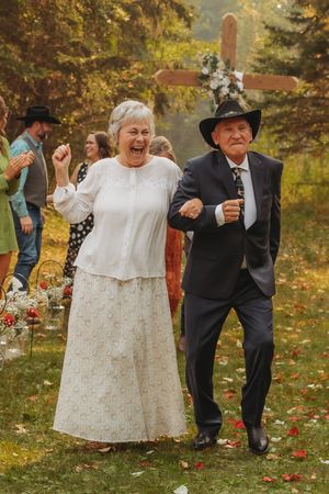 Senior couple dancing with joy on a beautiful fall day at an outdoor celebration.