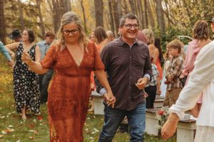 Wedding guests dance and celebrate during an outdoor autumn reception.