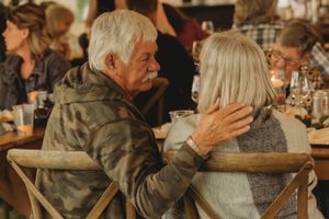 An intimate moment between two guests during a warm-lit reception dinner.