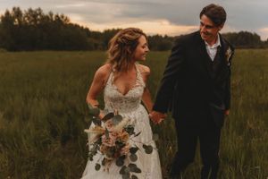 A romantic sunset portrait in a meadow with elegant wedding attire.