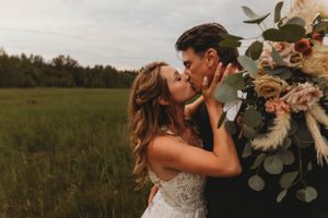 An intimate wedding portrait in a field with lush floral arrangements and soft lighting.
