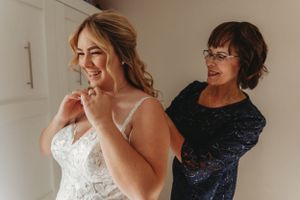 Getting ready moment with navy blue and white lace wedding attire.