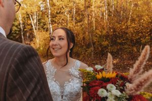An intimate wedding moment captured against vibrant fall foliage.