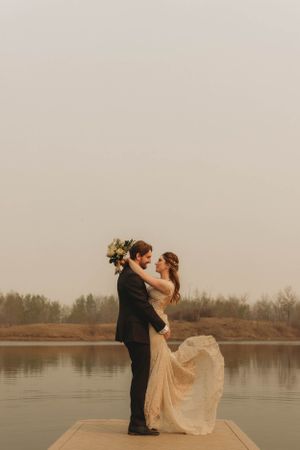 Romantic dock photo with elegant lace dress against misty lake background.