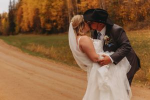 Couple shares intimate dance on country road surrounded by fall colors.