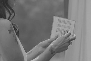 Close-up shot of hands holding a document during a wedding ceremony.