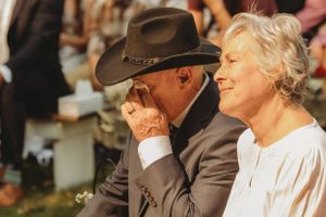 Couple sharing an emotional moment during an outdoor autumn ceremony.