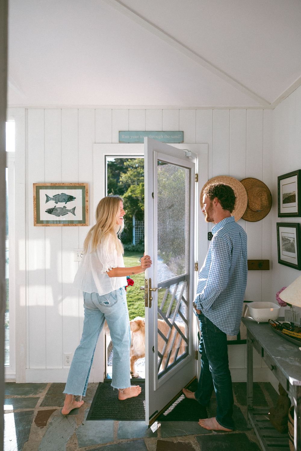 Couple chatting in a coastal cottage with white walls and nautical decor.
