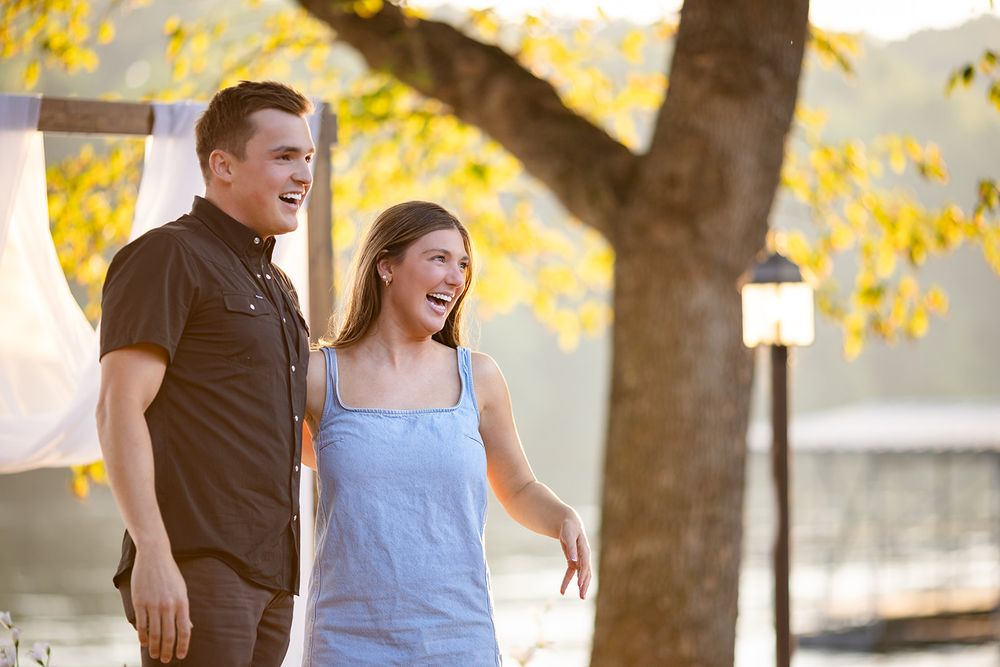 Just-engaged portrait of a couple walking and laughing along the White River in Mountain Home, Arkansas