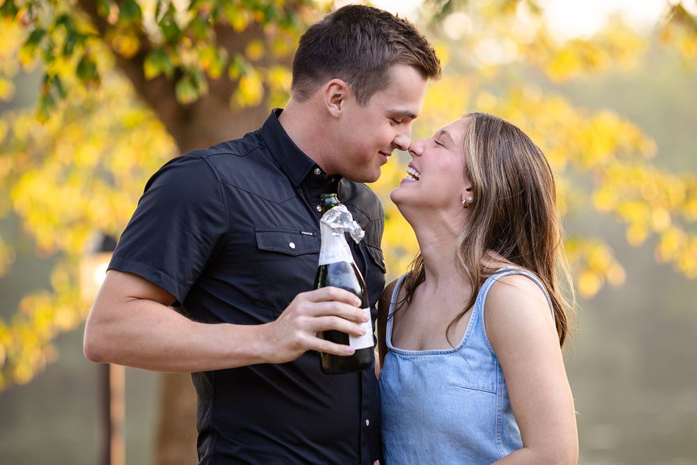 Close-up of a just-engaged couple laughing together with champagne after their proposal in Mountain Home, Arkansas