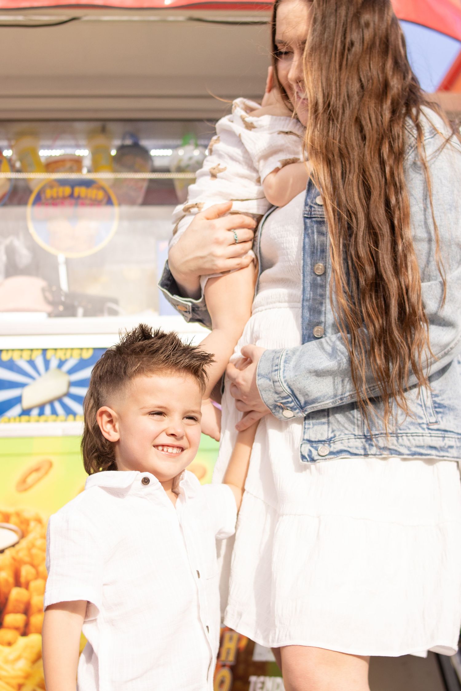 Little boy touching Moms pregnancy bump at the fair.