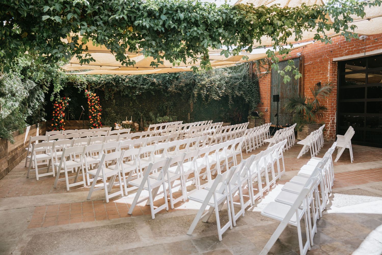 Outdoor ceremony seating arranged beneath fabric canopies in the Seventh Place courtyard.