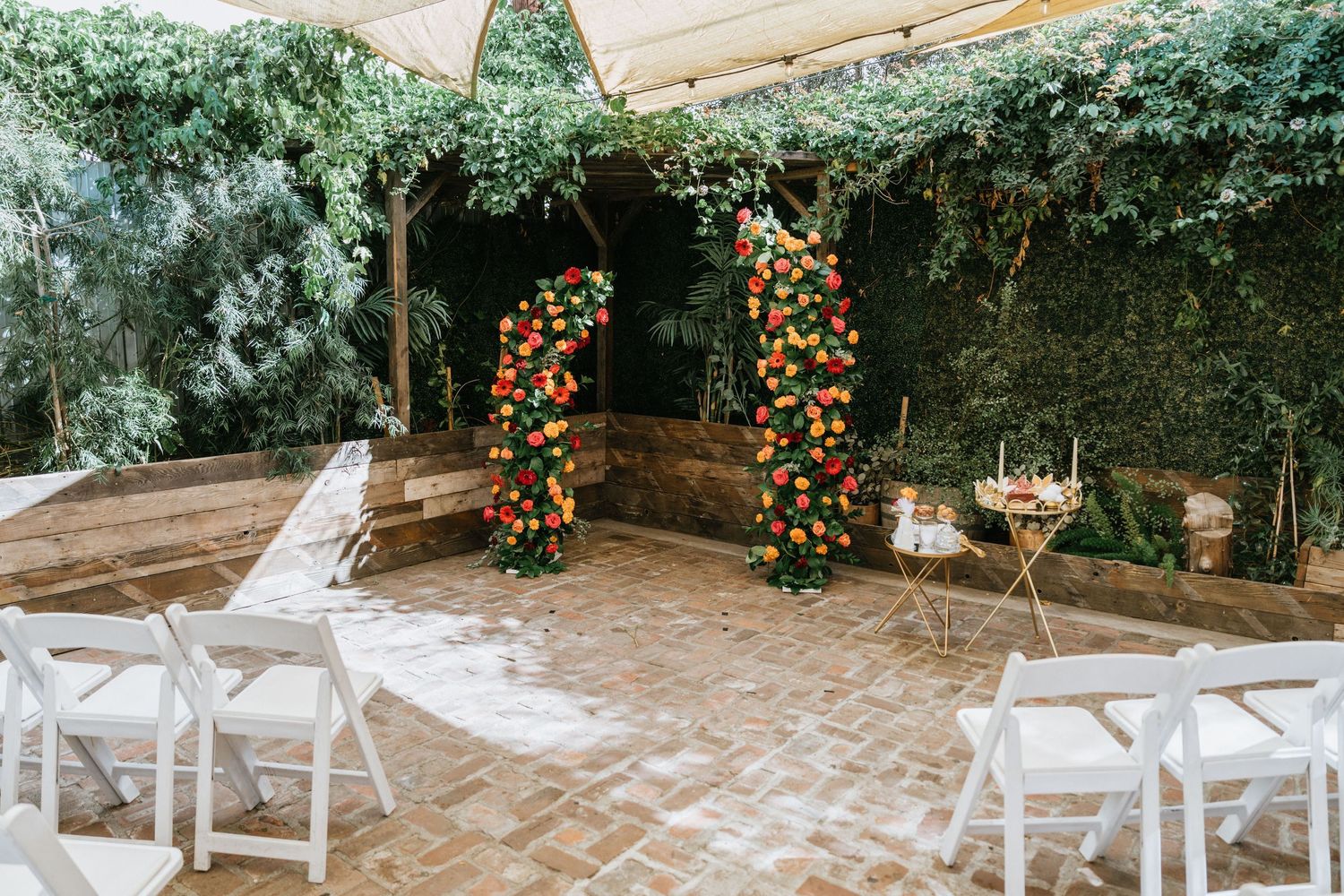 Colorful floral ceremony backdrop decorated with vibrant blooms at Seventh Place wedding venue.