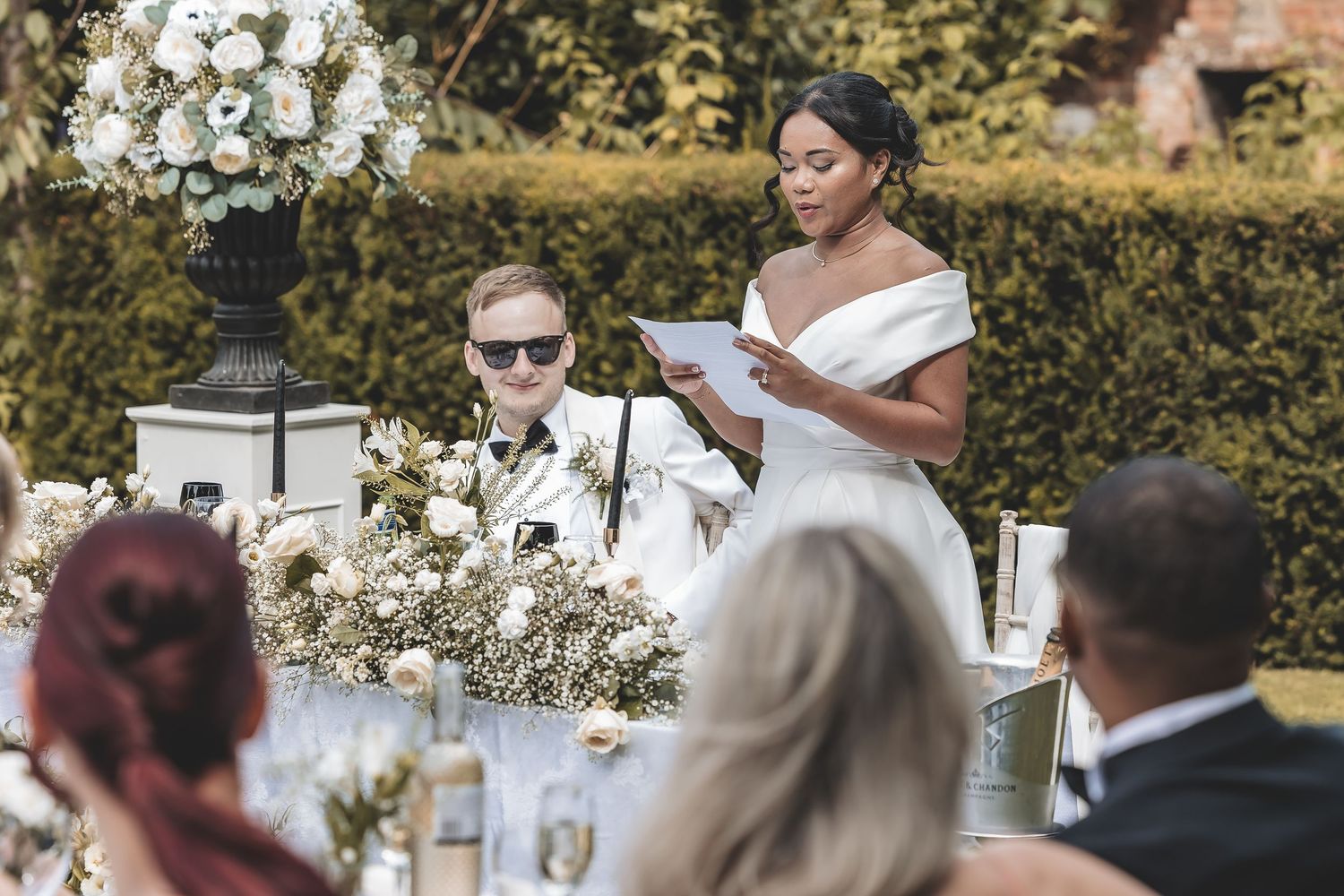 Bride and groom together at their drinks reception surrounded by their family and friends