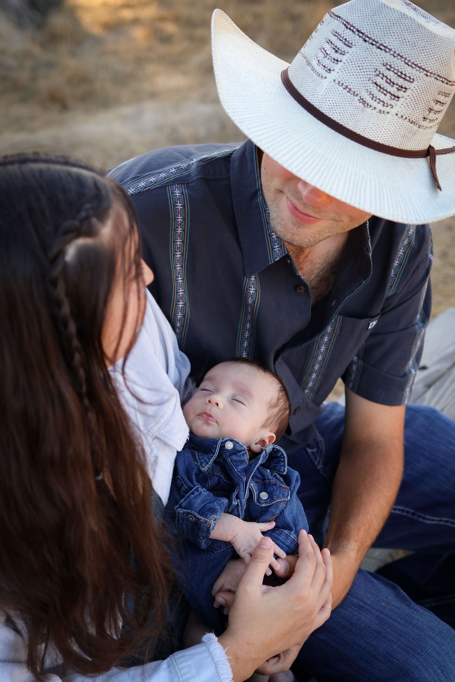 Couple holding new baby, looking into each others eyes