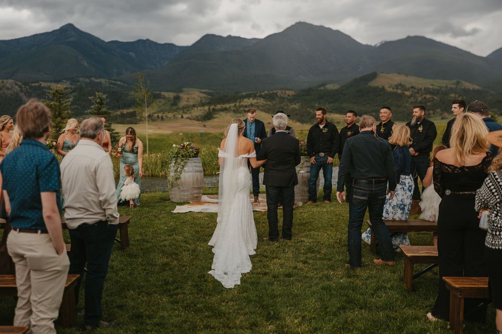 Bride walks down isle at Sage Lodge with her father on her rainy wedding day in Pray, Montana Paradise Valley captured by local photographer