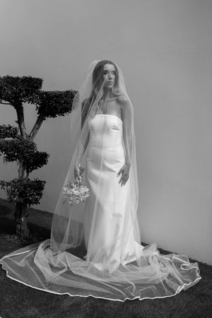 Artistic black and white bridal portraits with flowing veil and elegant wedding dress.