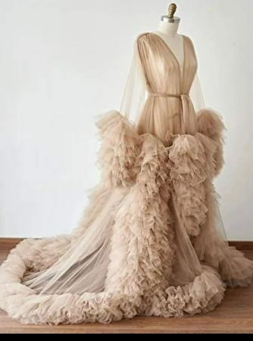 Elegant champagne tulle ruffled maternity gown with long sleeves and dramatic train on dress form.