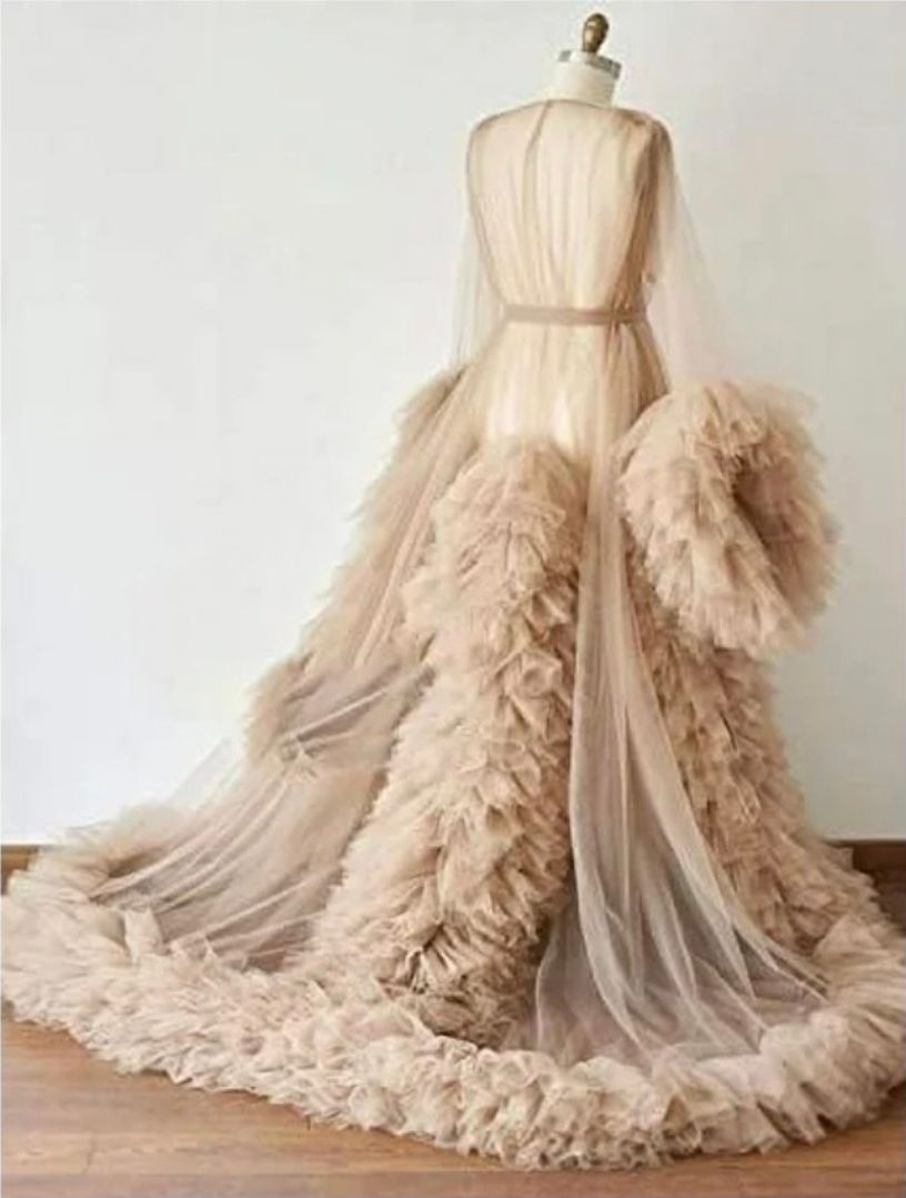Elegant champagne tulle ball gown with ruffled layers and long train displayed on a dress form.