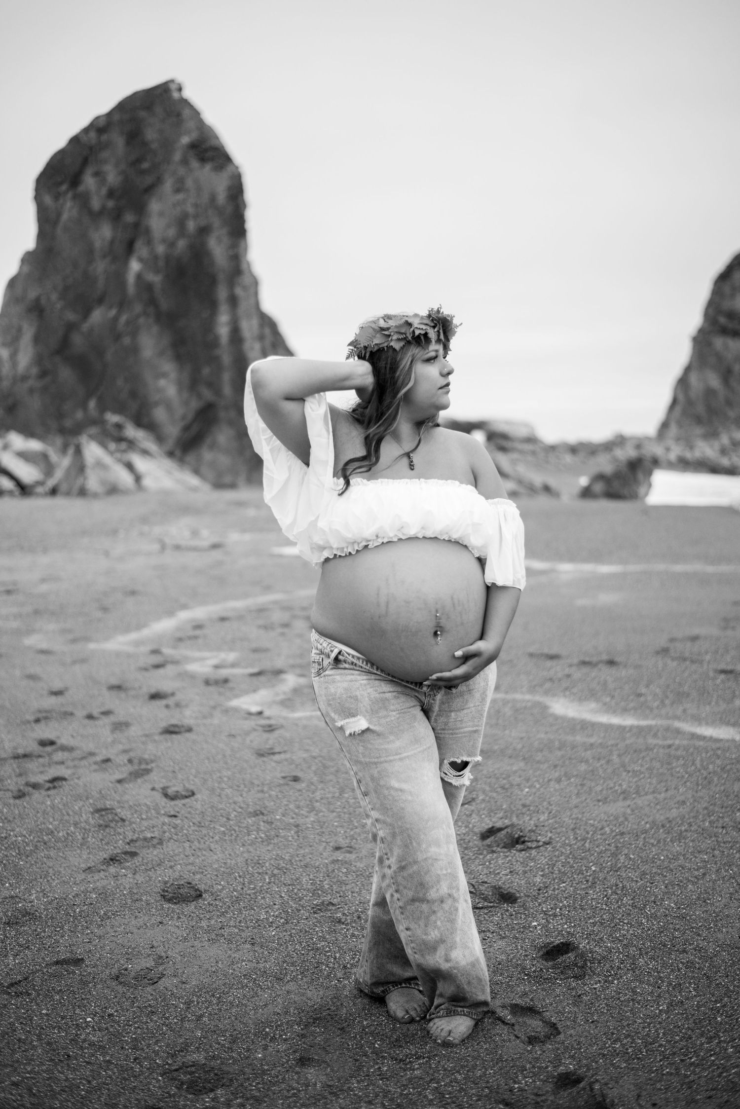 Cinematic maternity portrait of a woman at Goat Rock Beach, surrounded by rugged coastline, ocean air, and natural beauty.