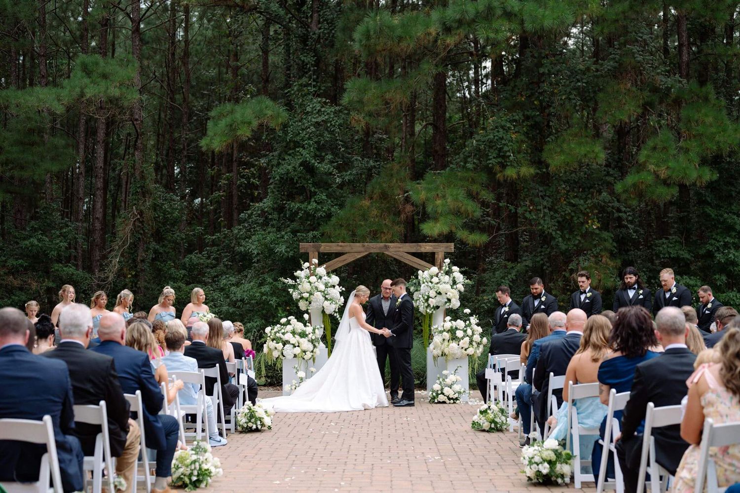 Bride and groom praying at ceremony altar at Historic Hill House in Willis Texas.