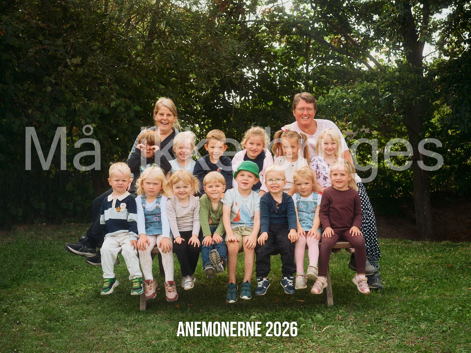 Group photo of children and two adults outdoors in a garden, labeled Anemonerne 2026.