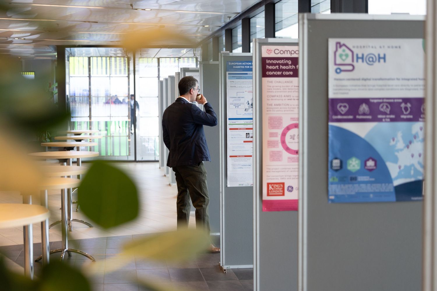 Business professional on phone call standing near exhibition display boards in a modern office space.