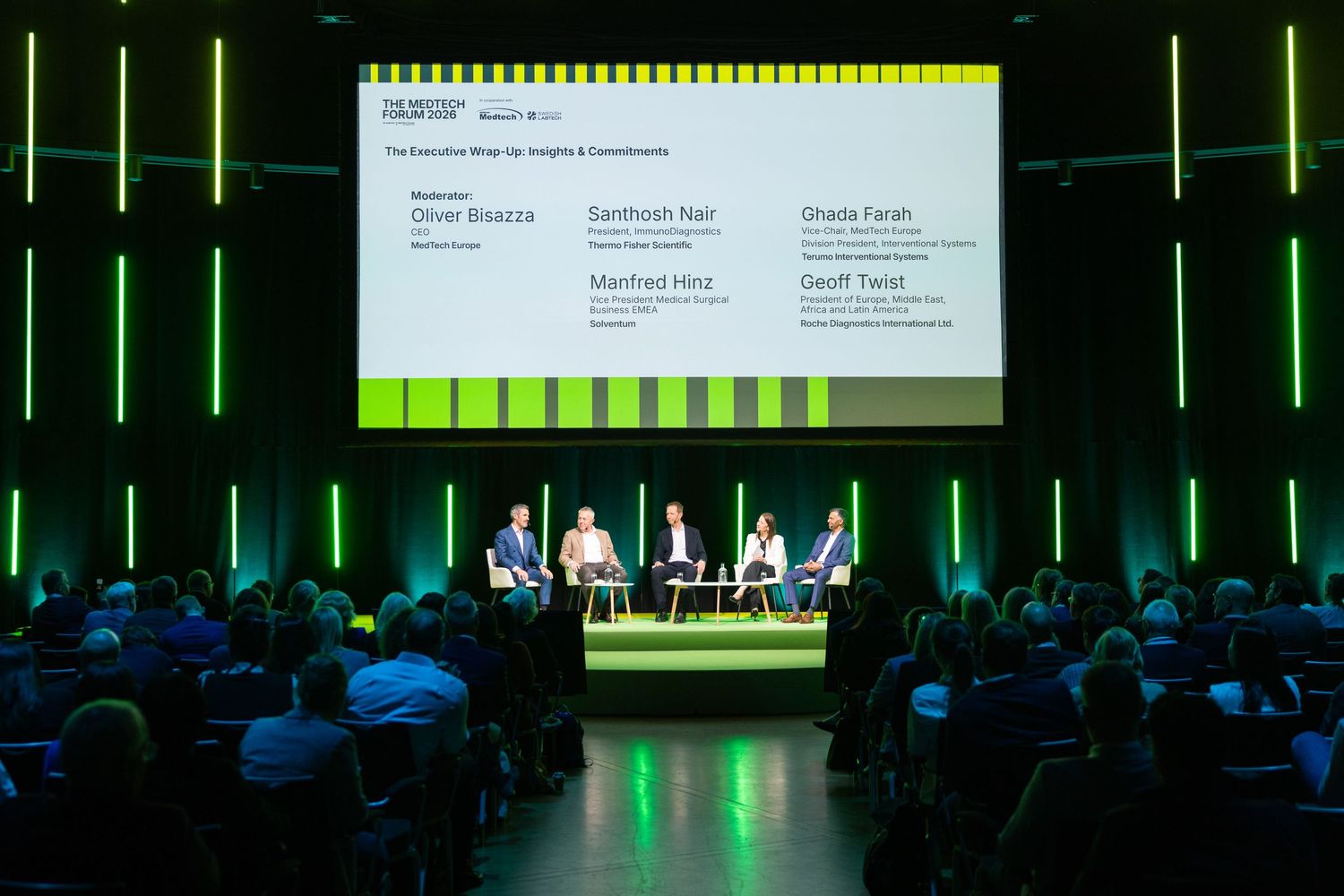 Panel discussion with four speakers on stage at a professional business conference.