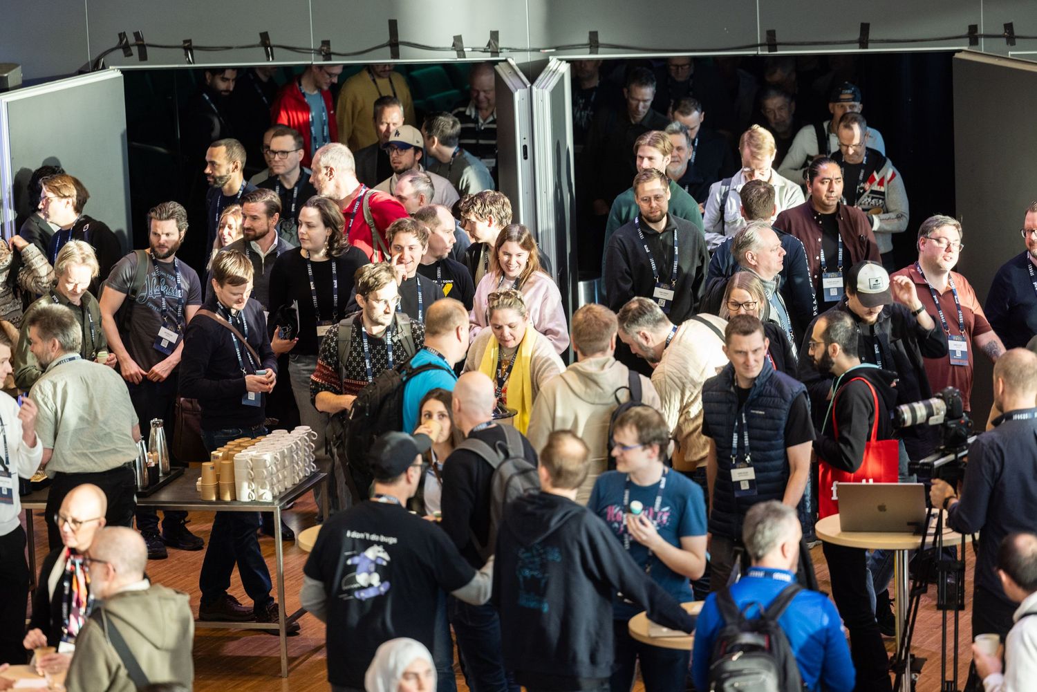 Large crowd of attendees networking and mingling at a busy technology conference event.