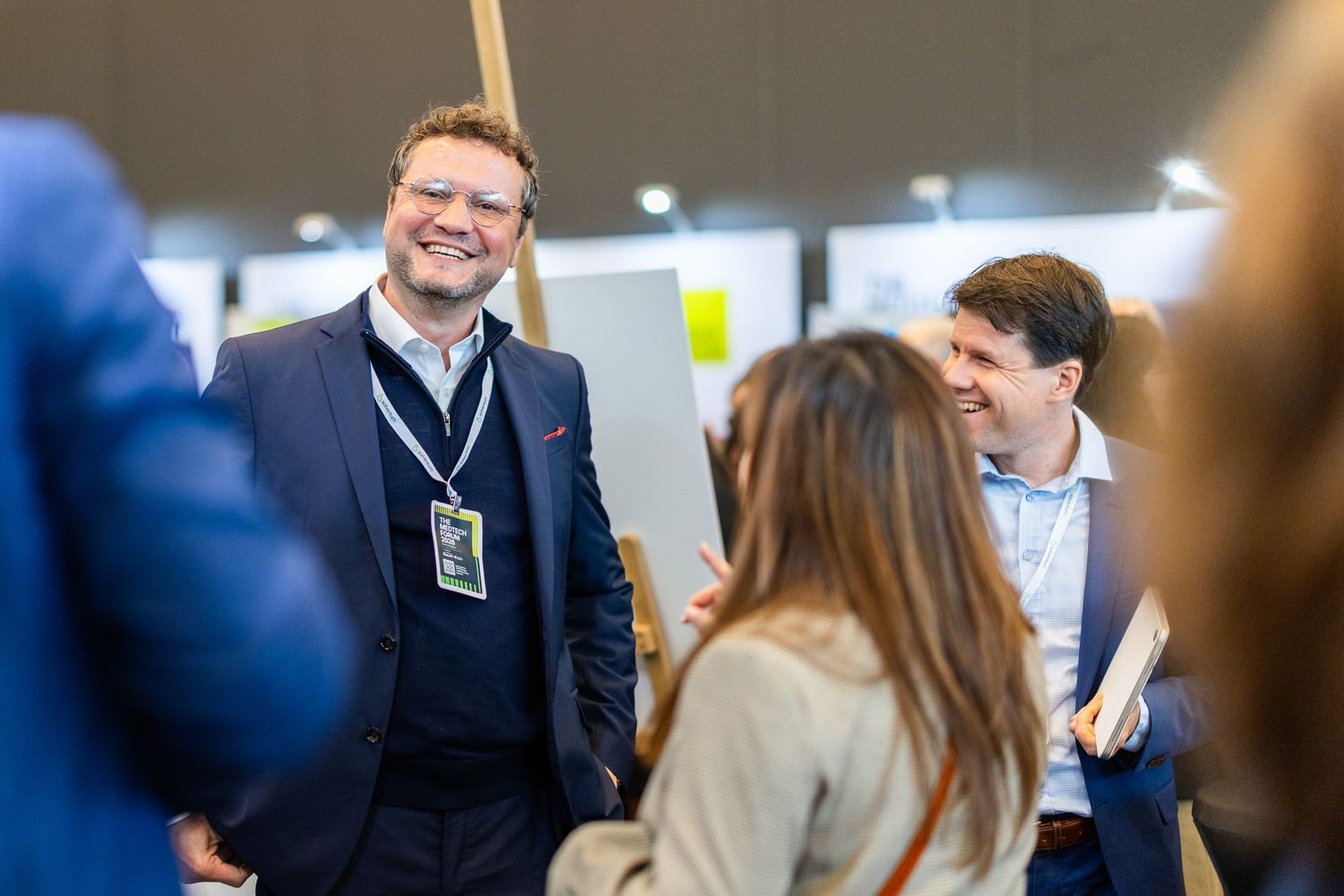 Businessman smiling and networking with colleagues at a professional conference event.
