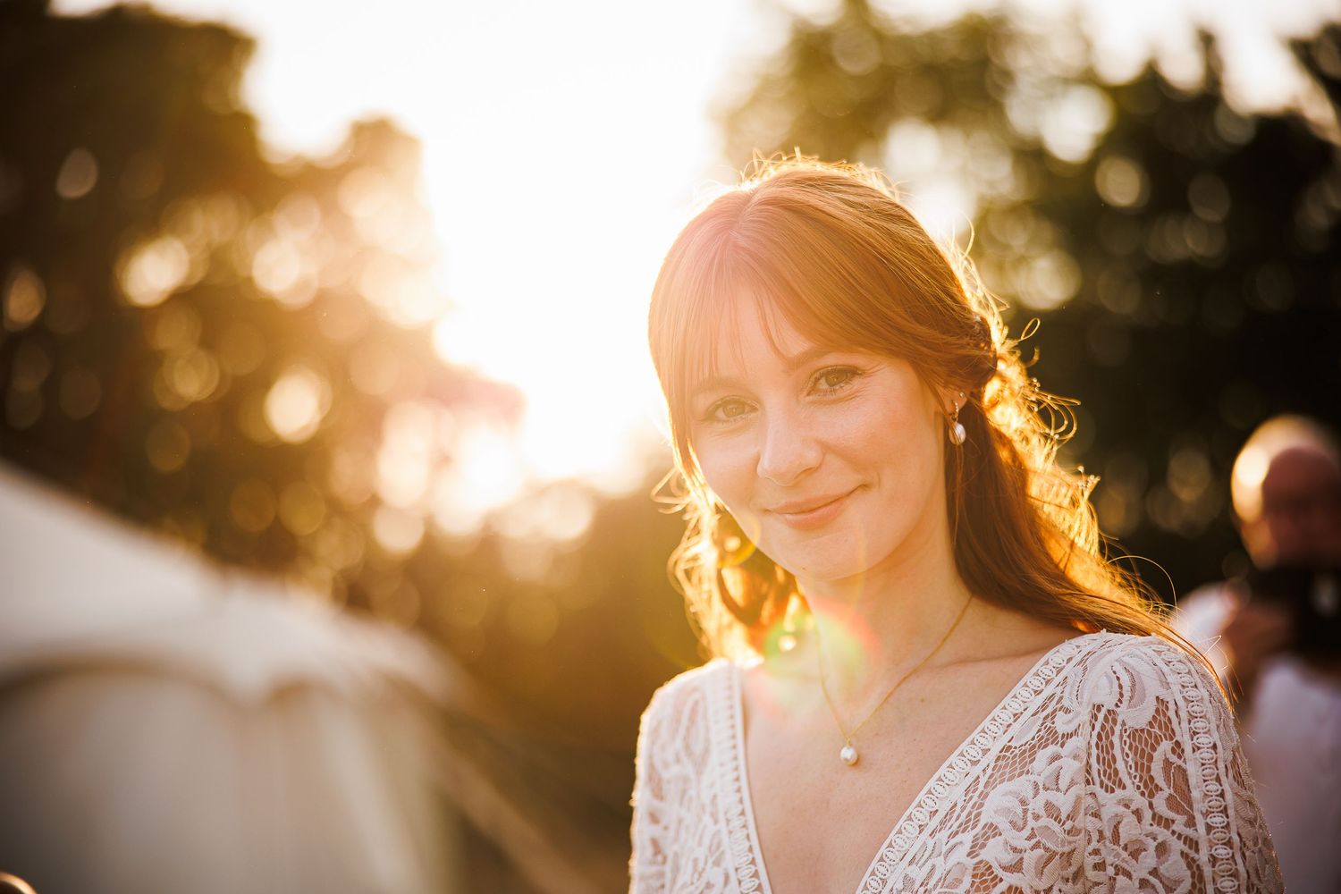 Bride and groom sitting on a floral swing surrounded by autumn leaves in an outdoor wedding portrait.
